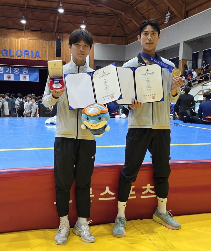 우슈 대표로 나선 권혁(울산상고·1)과 홍재훈(울산시우슈협회)이 메달과 상패를 들고 기념촬영을 하고 있다. 홍재훈은 남자일반부 산타 65kg급에서 금메달을, 권혁은 남자 18세 이하부 산타 65kg급에서 은메달을 따냈다. 시체육회 제공
