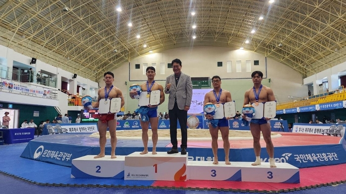 울주군 해뜨미씨름단이 지난 16일부터 22일까지 제주도 한림체육관에서 열린 ‘제107회 전국체육대회’에 울산시 대표로 출전해 개인전 금메달 2개, 은메달 1개를 획득하는 성과를 거뒀다. 이순걸 울주군수가 김덕일 선수와 기념촬영을 하고 있다. 울주군 제공