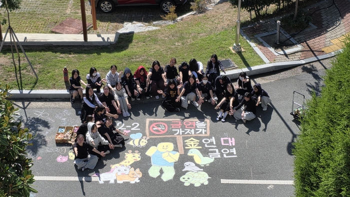 울산여자고 학생들이 지난 7~23일 교내 바닥에 흡연 예방 알림말을 그리고 기념사진을 찍고있다. 울산교육청 제공
