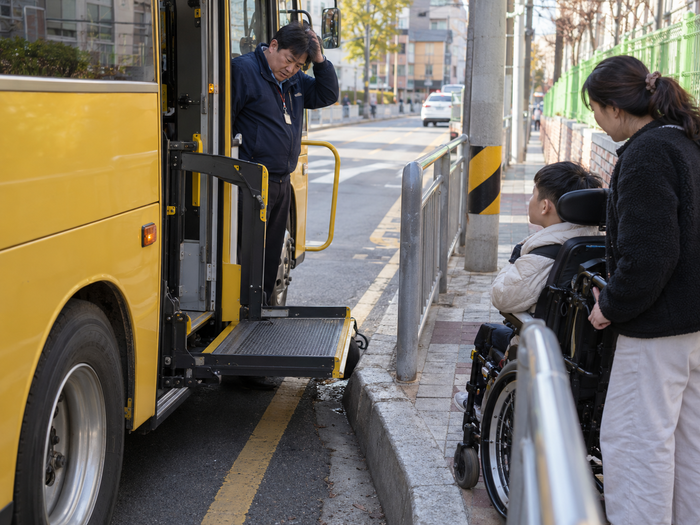 울산 특수학교 통학버스 28대가 운영되고 있지만 장애 학생의 안전한 승하차 공간이 부족하고 기존 버스정류장도 이용하기 어려워, 정류장 일시 정차 허용을 위한 법 개정과 시설 개선이 요구되고 있다. 생성형 AI로 만든 이미지.