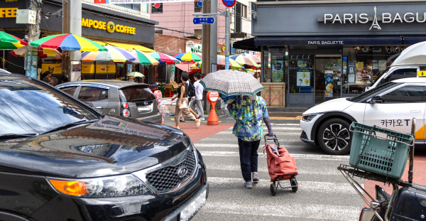 울산 중구 태화시장 앞 횡단보도에서 한 노인이 불법 주정차량이 시야를 가려 아찔하게 길을 건너고 있다. 울산매일 포토뱅크