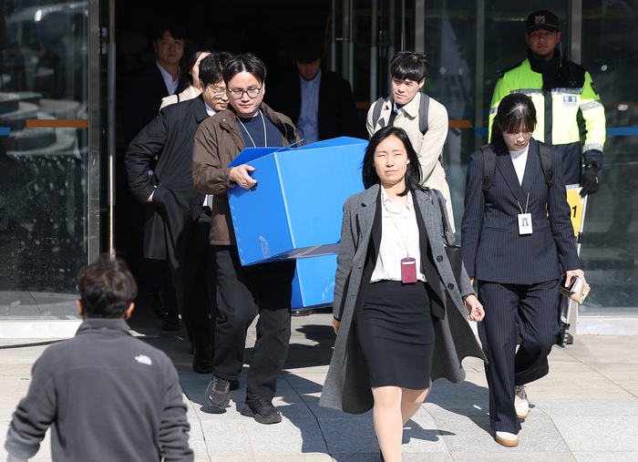 6·3 지방선거 투표용지 부족 사태 등을 수사하는 이태한 선거관리위원회 특별검사팀이 27일 서울 송파구 올림픽공원 핸드볼경기장을 압수수색했다. 특검 관계자들이 이날 상자를 들고 송파지역 개표소로 쓰인 핸드볼경기장을 나서고 있다. 연합뉴스.