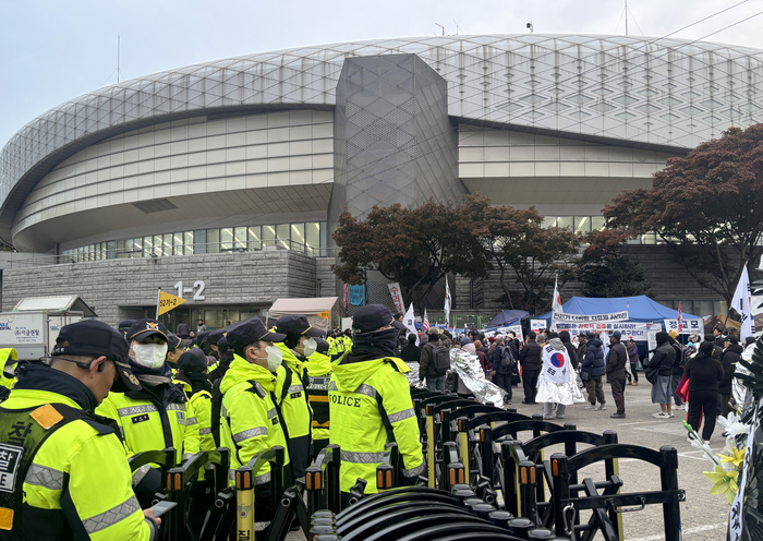 29일 서울 송파구 올림픽공원 핸드볼경기장에서 전날부터 진행된 6·3 지방선거 투표용지 부족 사태 관련 선관위 특검의 투표지 공개 검증과 투표함 반출이 끝난 뒤 경기장 앞 경찰 기동대 통제선 밖에 일부 시위대가 모여 있다. 연합뉴스